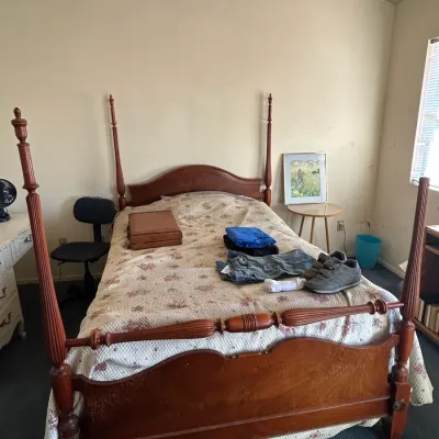 Vintage four-poster wooden bed frame with turned posts and a curved headboard and footboard, available for a buy-it-now price of $150.