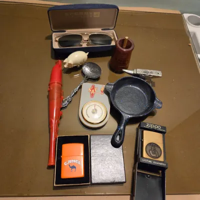 Sale Photo Thumbnail #136: Lot of misc stuff including cast iron pan ashtray, vintage sunglasses and a pair of new in package Camel branded zippo lighters
