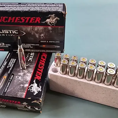 Two boxes of Winchester Ballistic Silvertip .243 Win 95 grain rifle ammunition, with one box opened to show the cartridges in a styrofoam...