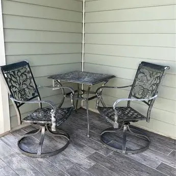 Sale Photo Thumbnail #31: Three-piece cast aluminum patio bistro set featuring two swivel rocker armchairs with ornate openwork backs and a matching square side table.