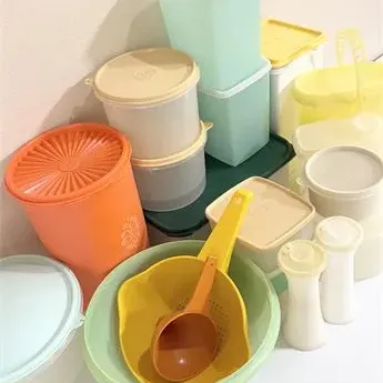 Sale Photo Thumbnail #30: Collection of vintage Tupperware kitchenware, including canisters, bowls, a colander, and salt and pepper shakers in retro pastel and harvest colors.