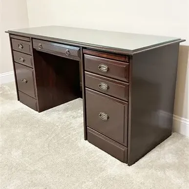 Sale Photo Thumbnail #48: Traditional dark wood double-pedestal executive desk featuring a protective glass top, brass-finished hardware, and multiple storage drawers.