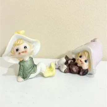 Sale Photo Thumbnail #10: Pair of vintage ceramic pixie figurines in pastel colors, featuring one sitting and one reclining pose.