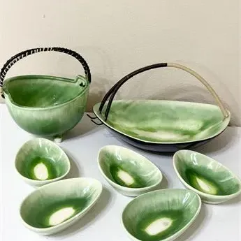 Sale Photo Thumbnail #45: Mid-century modern green drip glaze ceramic serving set, including a basket-handled bowl, a low handled dish, and five small oval individual bowls.