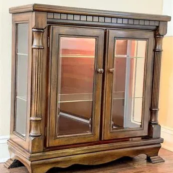 Sale Photo Thumbnail #14: Traditional dark wood curio cabinet featuring glass-front double doors, glass side panels, interior glass shelves, and fluted column accents.