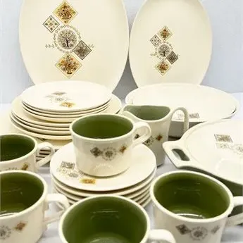 Sale Photo Thumbnail #15: Vintage mid-century modern dinnerware set featuring a cream base with olive green interiors on the cups and a stylized geometric tree pattern.