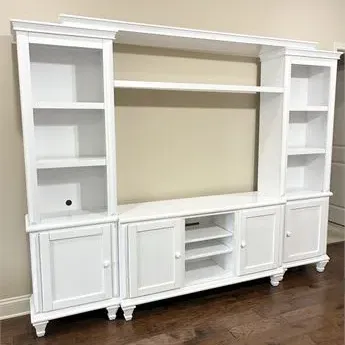 Sale Photo Thumbnail #44: Large white-painted wooden entertainment center featuring flanking bookshelves, lower cabinets, open media shelving, and a top bridge shelf.