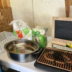 Assorted household items including an electric indoor grill, a stainless steel roasting pan, a wire dish rack, paper napkins, plastic...