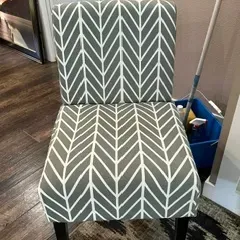 Sale Photo Thumbnail #46: Contemporary armless accent chair featuring a grey and white chevron-patterned fabric upholstery and dark wood legs.