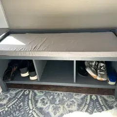 Sale Photo Thumbnail #33: Modern gray wooden entryway bench featuring a light gray seat cushion and three open storage cubbies underneath.