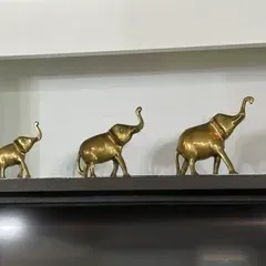 Sale Photo Thumbnail #50: Trio of vintage brass elephant figurines in graduated sizes, each depicted with its trunk raised.