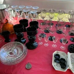 Sale Photo Thumbnail #38: Assortment of vintage glassware, including etched crystal stemware, black amethyst glass goblets, and clear pressed glass serving plates.