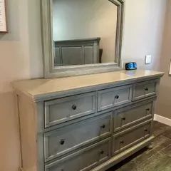 Sale Photo Thumbnail #60: Contemporary seven-drawer dresser with a matching arched wall mirror, featuring a distressed gray finish and dark metal knobs.