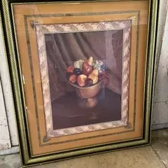 Framed still life print depicting a bowl of fruit, presented in an ornate gold-toned frame with multi-layered matting.