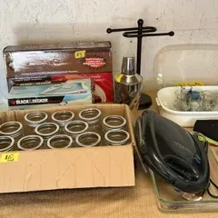 Assorted kitchenware and small appliances, including a box of glass canning jars, a Black & Decker iron, a cocktail shaker, and a...