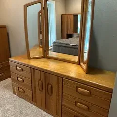 Sale Photo Thumbnail #29: Vintage light oak dresser with a central double-door cabinet, six drawers with integrated wooden pulls, and a matching tri-fold mirror, circa 1980s.