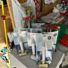 Collection of vintage GE electric window candles in original packaging, alongside other holiday decorations.