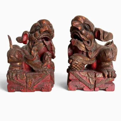 Sale Photo Thumbnail #72: Pair of antique Chinese hand-carved wooden Foo Dog statues with a weathered red and gold lacquer finish.