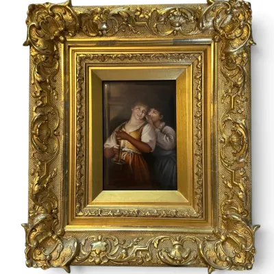 Sale Photo Thumbnail #62: Antique hand-painted porcelain plaque depicting two young women, housed in an ornate, heavily carved giltwood frame.