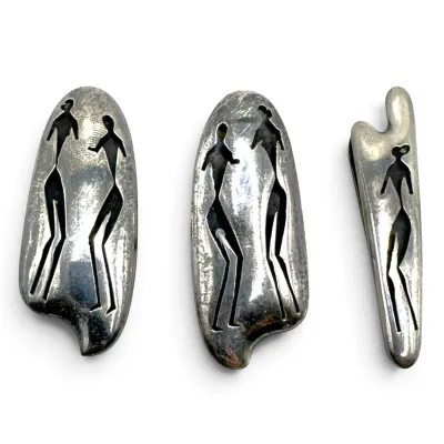 Sale Photo Thumbnail #155: Three mid-century modern sterling silver jewelry pieces featuring stylized, cutout stick figures in a modernist design.
