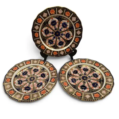 Sale Photo Thumbnail #5: Three Royal Crown Derby Imari pattern porcelain plates, featuring intricate cobalt blue, rust orange, and gold gilt floral designs.