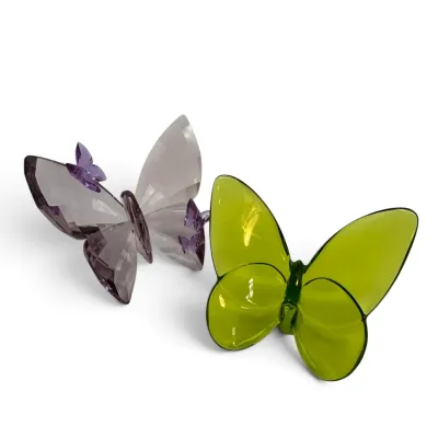 Sale Photo Thumbnail #20: Two crystal butterfly figurines, including a faceted purple Swarovski-style butterfly and a smooth, chartreuse green Baccarat-style butterfly.