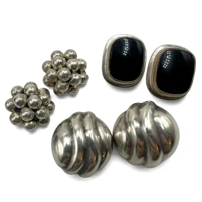 Sale Photo Thumbnail #115: Three pairs of vintage sterling silver clip-on earrings, including a beaded cluster design, a ribbed dome style, and a pair featuring bezel-set black onyx stones.