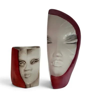 Sale Photo Thumbnail #39: Pair of modern ceramic face sculptures in contrasting white and deep red glazes, featuring stylized, minimalist facial features.