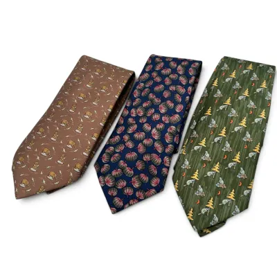 Sale Photo Thumbnail #161: Hermes Trio of vintage patterned silk neckties, featuring a brown tie with a bear motif, a blue tie with a pumpkin pattern, and a green tie with a beaver and pine tree design.