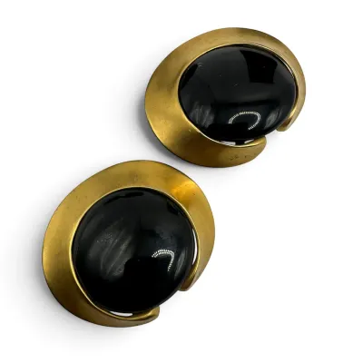 Sale Photo Thumbnail #123: Vintage 1980s clip-on earrings featuring large, polished black cabochons set in brushed gold-tone metal frames.