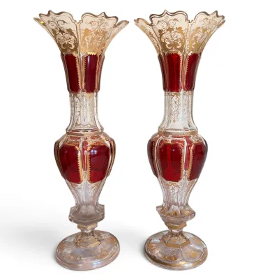 Sale Photo Thumbnail #48: Pair of antique Bohemian ruby stained cut-to-clear glass vases, featuring intricate gold gilt scrollwork and scalloped rims.