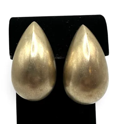Sale Photo Thumbnail #125: Pair of vintage gold-tone teardrop clip-on earrings with a brushed satin finish, displayed on a black velvet stand.