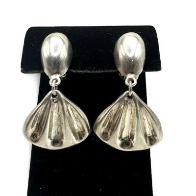 Sale Photo Thumbnail #138: Vintage sterling silver clip-on earrings featuring a teardrop post and a dangling fan or shell motif, showing some natural patina.