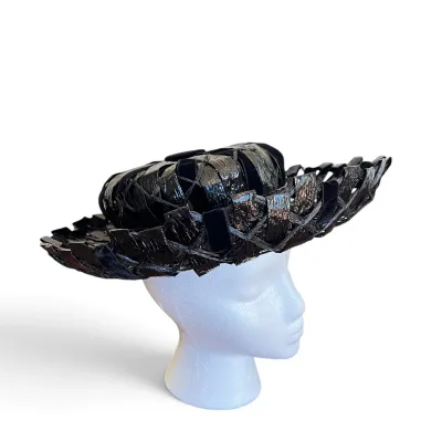 Sale Photo Thumbnail #165: Vintage mid-century black woven straw hat with a glossy finish and velvet ribbon accents, displayed on a white styrofoam mannequin head.