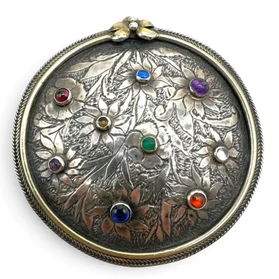 Sale Photo Thumbnail #111: Vintage round sterling pin featuring an embossed floral design accented with multi-colored cabochon stones.