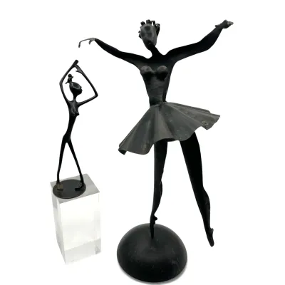 Sale Photo Thumbnail #56: Two mid-century modern style black metal ballerina sculptures, one larger figure on a domed base and a smaller, stylized figure mounted on a clear acrylic block pedestal.