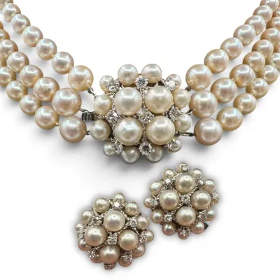 Sale Photo Thumbnail #152: Vintage three-strand pearl necklace with an ornate pearl and rhinestone clasp, paired with matching cluster clip-on earrings.