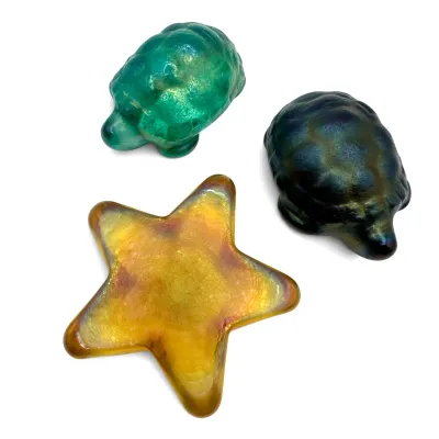 Sale Photo Thumbnail #19: Trio of vintage iridescent art glass paperweights, including a yellow starfish and two turtles in green and dark blue hues.
