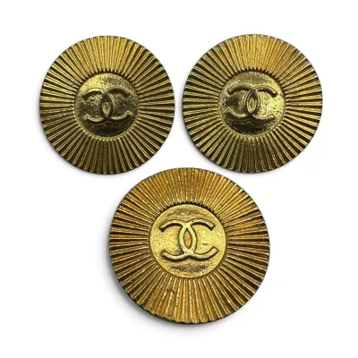 Sale Photo Thumbnail #151: Set of three vintage Chanel gold-tone buttons featuring the iconic interlocking CC logo centered within a sunburst design.