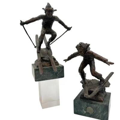 Sale Photo Thumbnail #57: Pair of vintage bronze skier figurines mounted on green marble bases, one featuring an additional clear acrylic display stand.