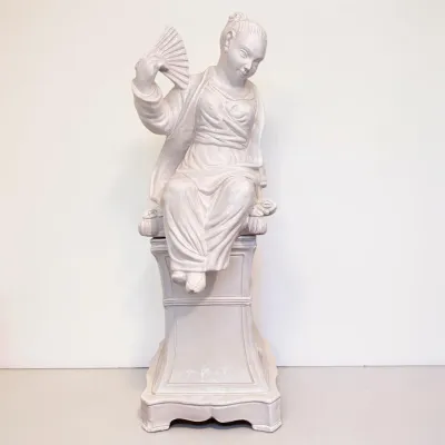 Sale Photo Thumbnail #15: Vintage white plaster or ceramic statue depicting a seated Asian woman holding a fan, mounted on a matching pedestal base.