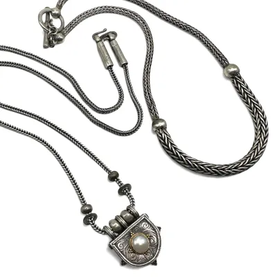 Sale Photo Thumbnail #112: Two sterling silver woven chain necklaces, including one with a toggle clasp and another featuring an ornate shield-shaped pendant set with a single pearl.