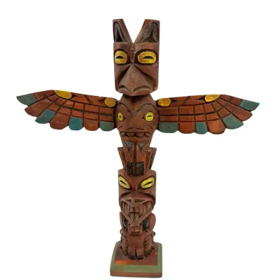 Sale Photo Thumbnail #77: Vintage hand-carved wooden totem pole featuring a Thunderbird with outstretched wings, painted with yellow, green, and black accents.