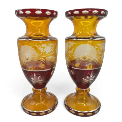 Sale Photo Thumbnail #49: Pair of Bohemian cut-to-clear glass urn vases featuring amber and ruby red tones with etched floral designs.