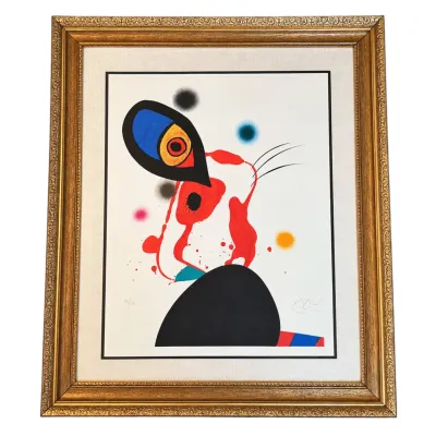 Sale Photo Thumbnail #174: Joan Miró signed and numbered limited edition lithograph, featuring abstract surrealist figures in bold primary colors, presented in an ornate gold-finished frame with a linen mat.