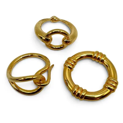 Sale Photo Thumbnail #149: Three Hermes vintage gold-tone scarf rings in various sculptural and ribbed designs, showing light surface wear.