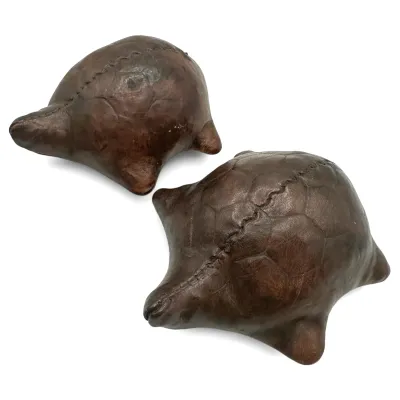Sale Photo Thumbnail #85: Pair of vintage stitched leather turtle-shaped footstools or decorative objects, featuring a rich brown patina and hand-stitched details.