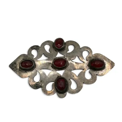 Sale Photo Thumbnail #109: Vintage silver-tone openwork brooch featuring five oval red cabochon stones in bezel settings, showing some age-related tarnish.
