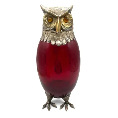 Sale Photo Thumbnail #33: Antique Victorian-style owl decanter featuring a ruby red glass body, detailed silver-plated head and feet, and amber glass eyes.