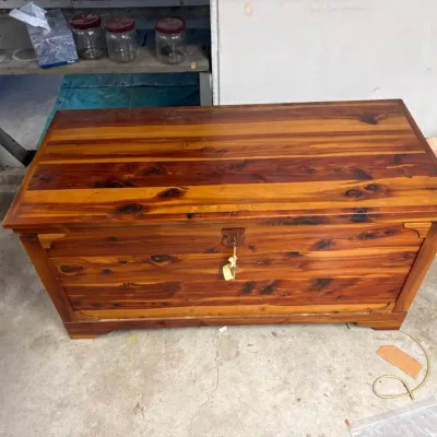 Sale Photo Thumbnail #35: Vintage cedar hope chest featuring a rich, knotted wood grain finish and a central key lock.